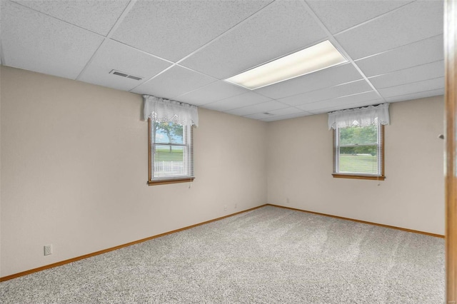 carpeted spare room featuring a paneled ceiling