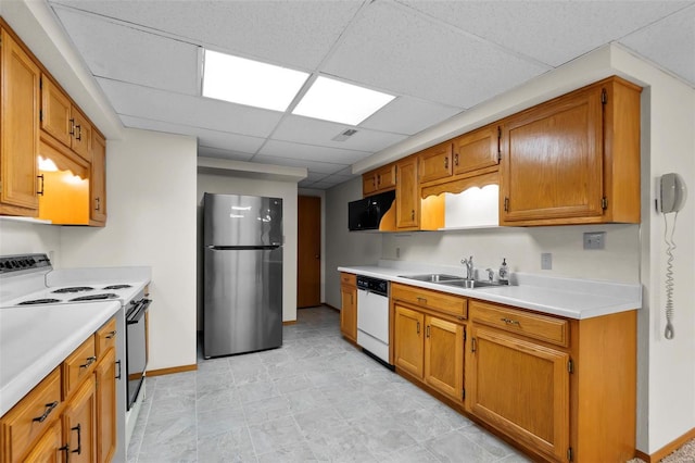 kitchen with white appliances, a drop ceiling, sink, and light tile patterned floors