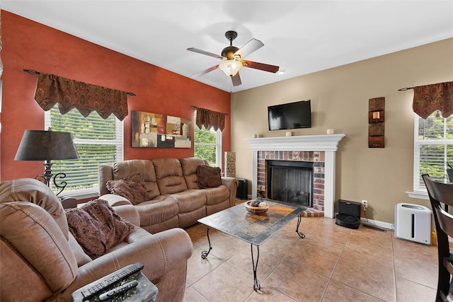 living room with ceiling fan, light tile patterned floors, and a brick fireplace