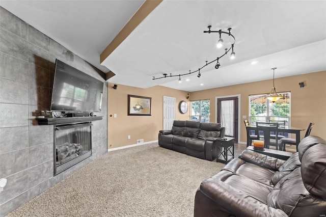 living room featuring tile walls, a fireplace, and carpet floors