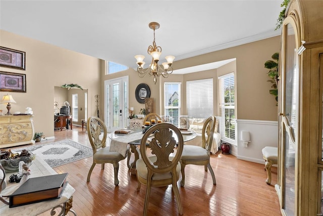 dining space featuring ornamental molding, a chandelier, and hardwood / wood-style flooring