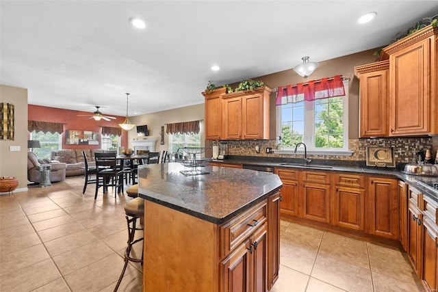 kitchen with a healthy amount of sunlight, ceiling fan, sink, and a kitchen island