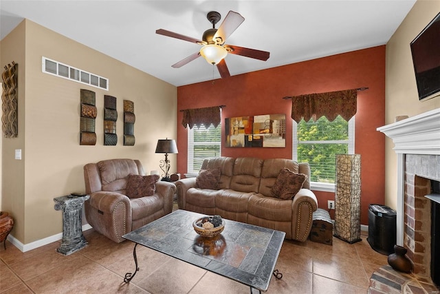 tiled living room with ceiling fan and a brick fireplace