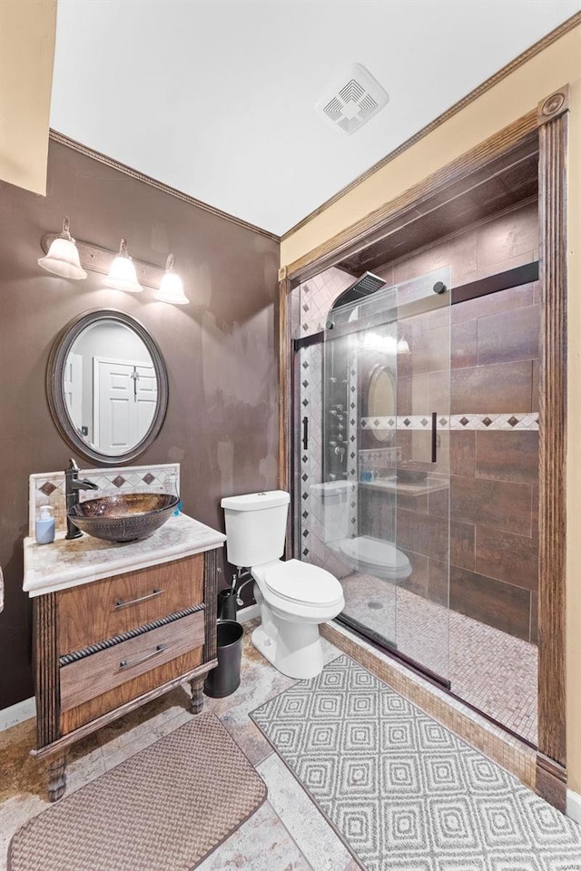 bathroom with vanity, toilet, and a shower with door