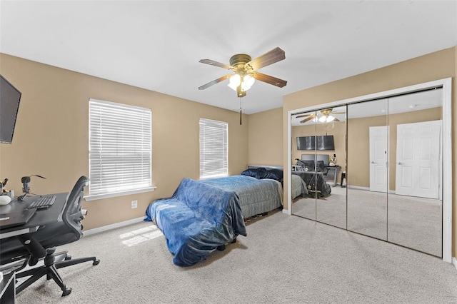 bedroom with light colored carpet, ceiling fan, and a closet