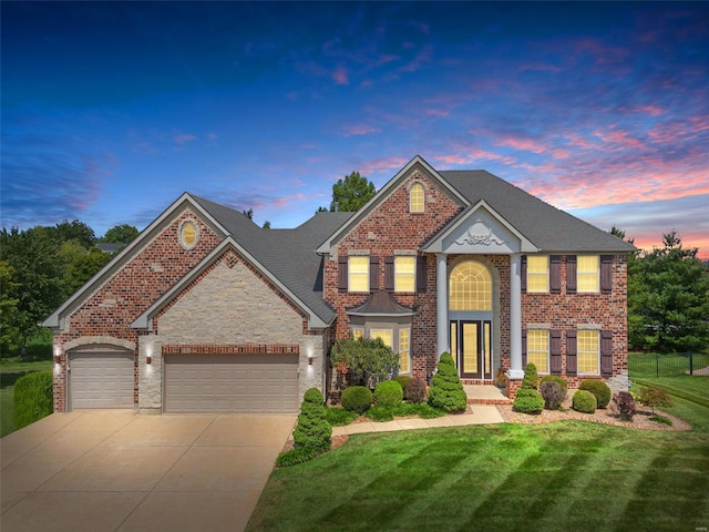 view of front of house featuring a garage and a yard