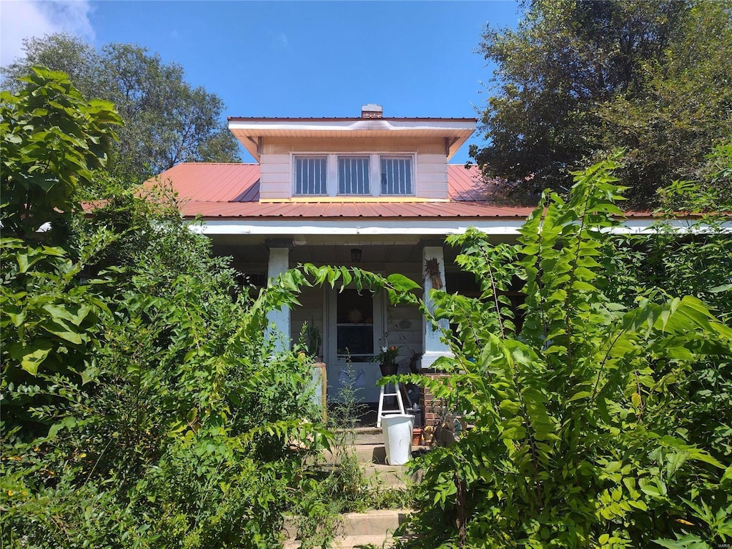 bungalow-style home with metal roof and a porch