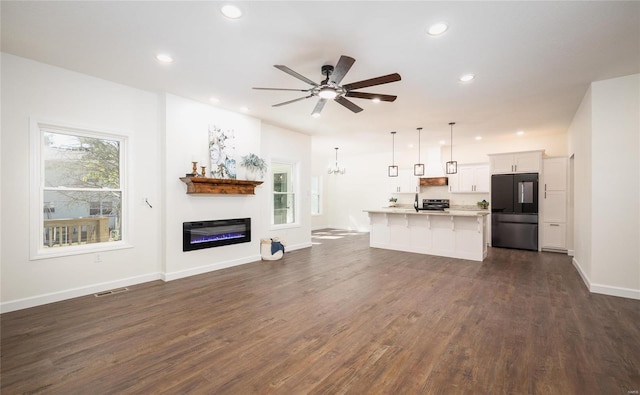 unfurnished living room with dark hardwood / wood-style floors and ceiling fan