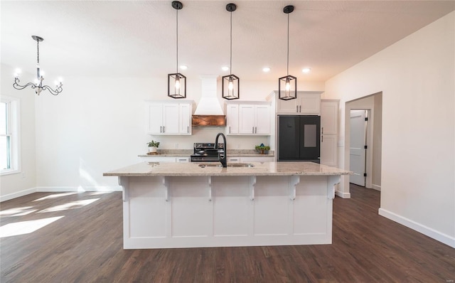 kitchen featuring pendant lighting, sink, black refrigerator, and custom exhaust hood