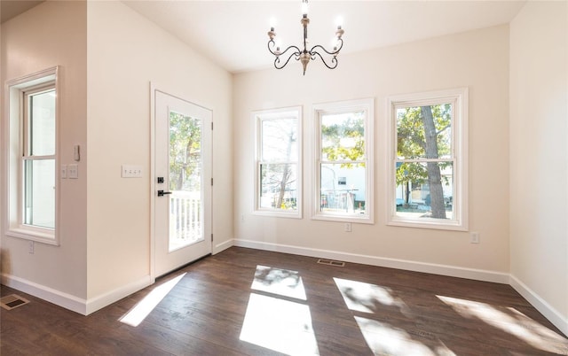 doorway to outside featuring dark hardwood / wood-style floors and a chandelier