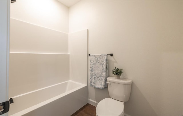 bathroom with bathing tub / shower combination, toilet, and wood-type flooring