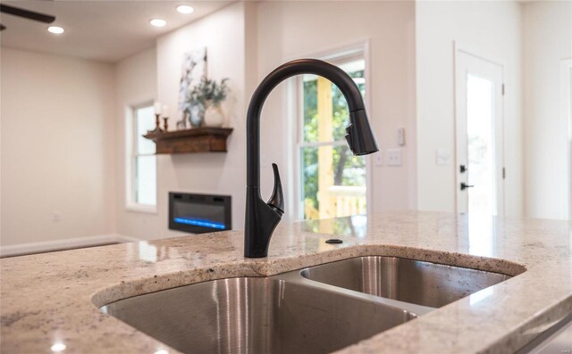 kitchen with light stone counters and sink