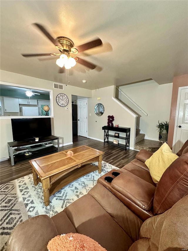 living room featuring ceiling fan and dark hardwood / wood-style floors