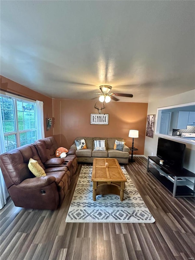 living room featuring ceiling fan and dark hardwood / wood-style floors