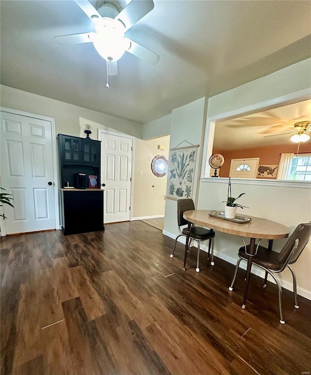 living room featuring ceiling fan and dark wood-type flooring