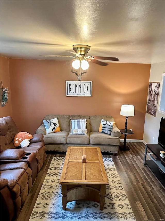 living room featuring ceiling fan and dark hardwood / wood-style floors