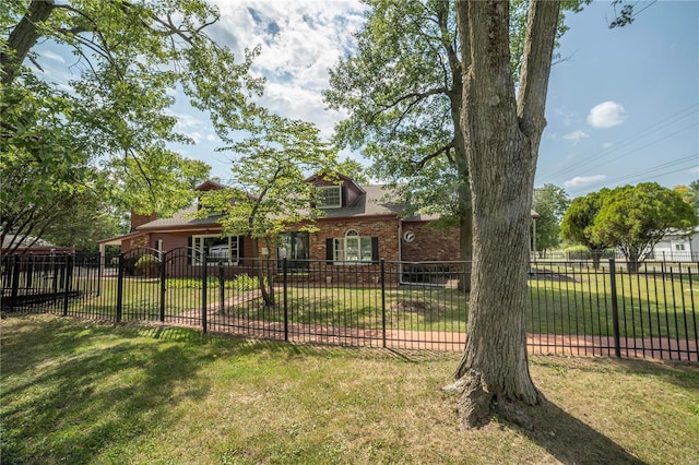 view of front of house featuring brick siding, a front lawn, and a fenced front yard