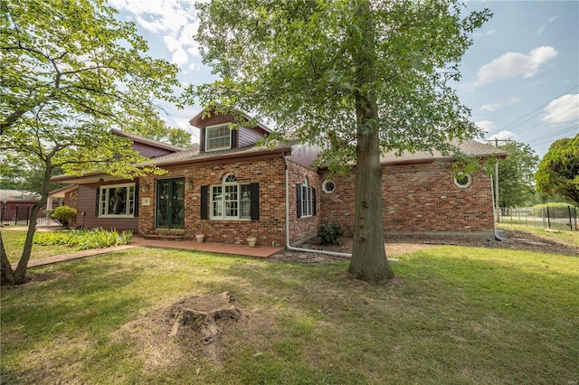 view of front of property featuring a front yard, fence, and brick siding