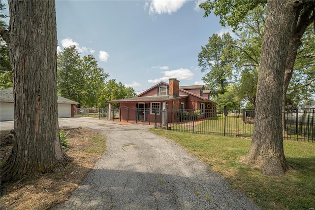 view of front of property featuring a garage, a fenced front yard, a chimney, and a front yard