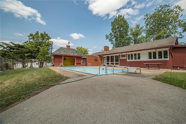 back of house featuring a patio, a lawn, fence, and a fenced in pool