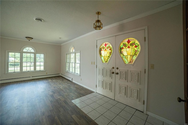 entrance foyer with visible vents, baseboard heating, crown molding, and french doors