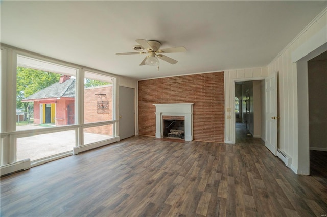 unfurnished living room featuring a baseboard heating unit, brick wall, a fireplace with flush hearth, and wood finished floors