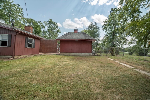 view of yard with an outbuilding, fence, and a shed