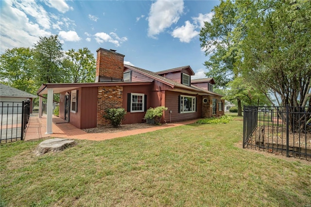 back of house with a yard, a chimney, a patio, and fence