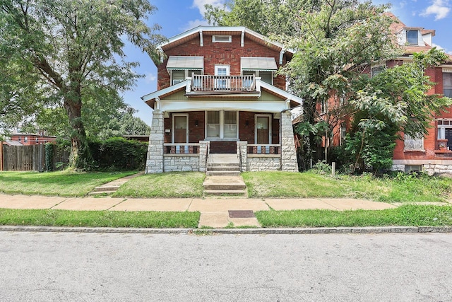 craftsman-style house featuring a balcony, a porch, and a front yard