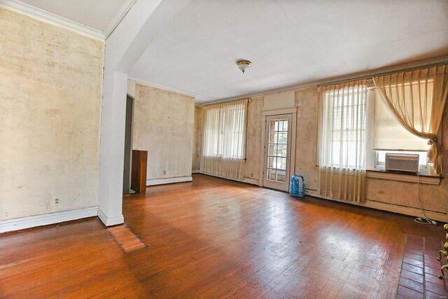 unfurnished living room with cooling unit, dark hardwood / wood-style flooring, and crown molding