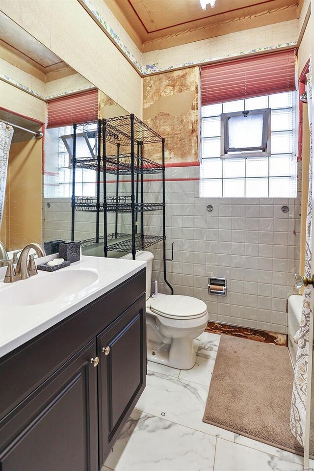 full bathroom featuring tile walls, toilet, shower / tub combo, vanity, and tile patterned flooring