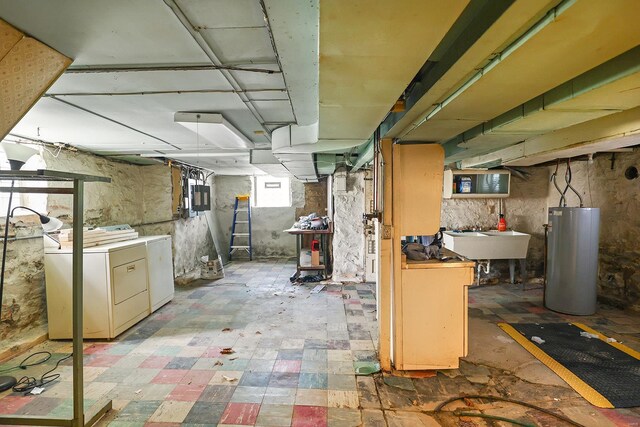 basement with water heater, tile patterned floors, sink, and separate washer and dryer