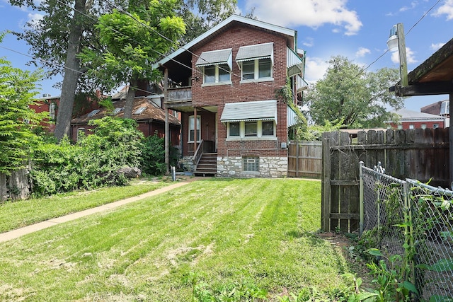 rear view of property with a lawn and a balcony