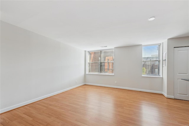 unfurnished room with light wood-style floors and baseboards