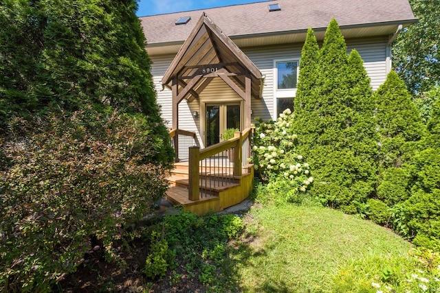 rear view of house with roof with shingles