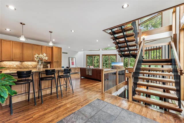 staircase featuring lofted ceiling and wood-type flooring