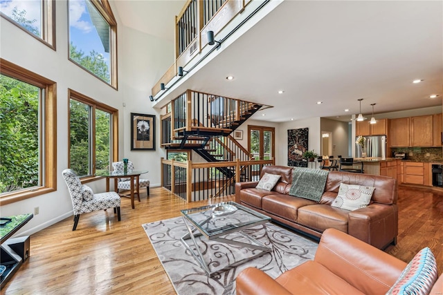 living area featuring light wood-type flooring, plenty of natural light, stairway, and recessed lighting