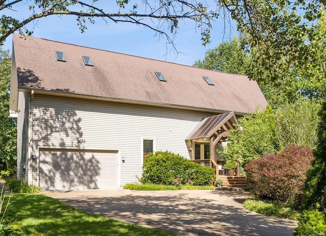 view of home's exterior with a garage, driveway, and a shingled roof