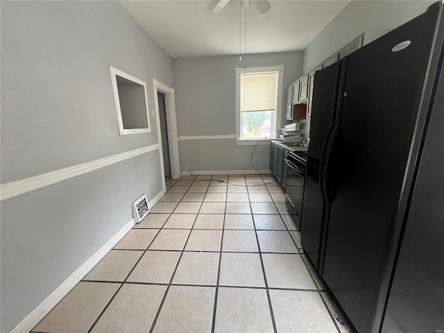 kitchen featuring light tile patterned flooring, black fridge, and ceiling fan