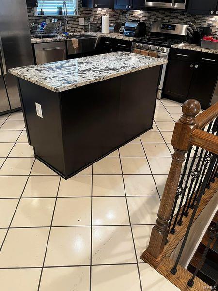 interior space with decorative backsplash and light tile patterned floors