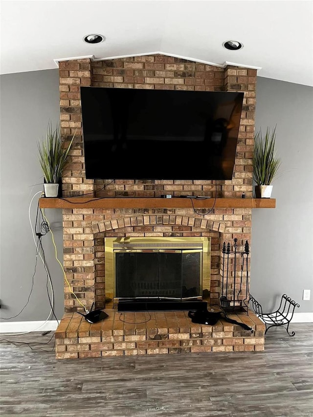 interior details featuring wood-type flooring and a brick fireplace