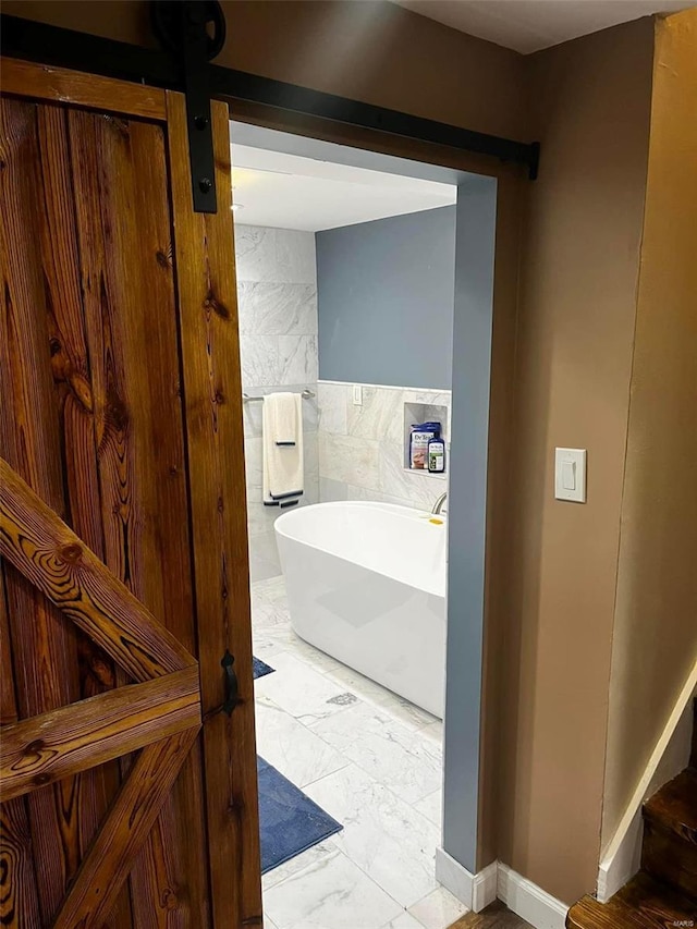 bathroom featuring tile patterned flooring, tile walls, and a washtub