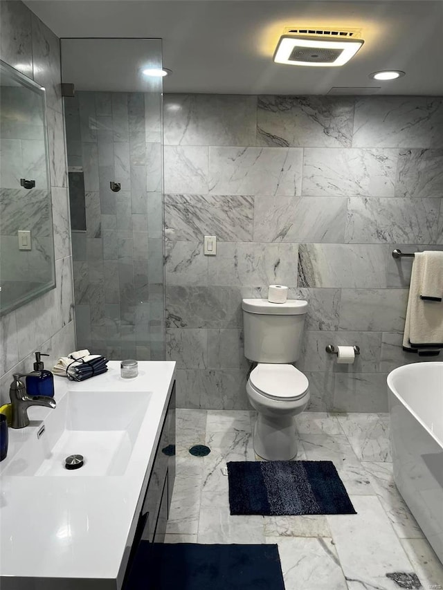 bathroom featuring tile walls, vanity, tile patterned floors, and toilet