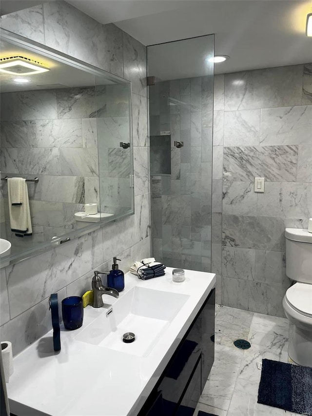 bathroom with a shower, toilet, vanity, and tile walls