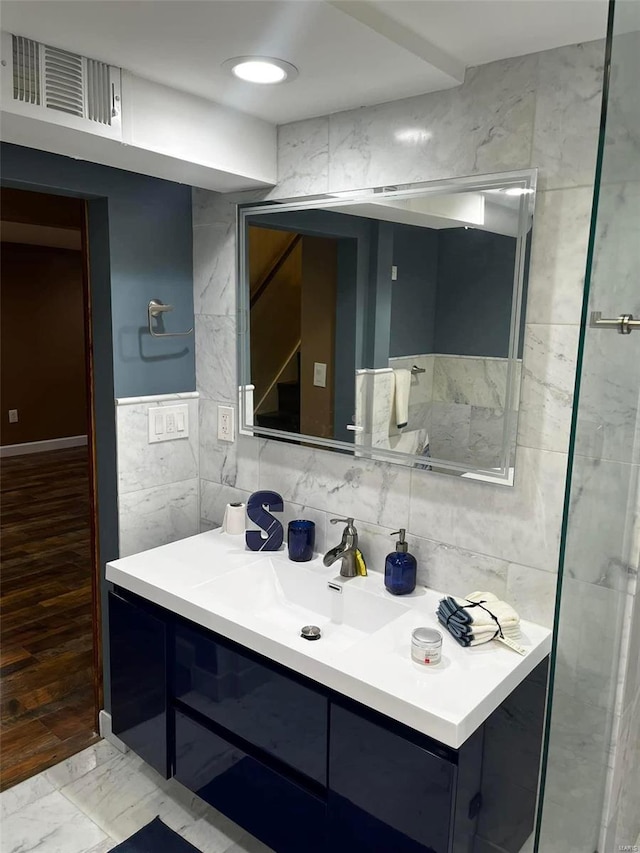 bathroom featuring hardwood / wood-style flooring, vanity, and tile walls