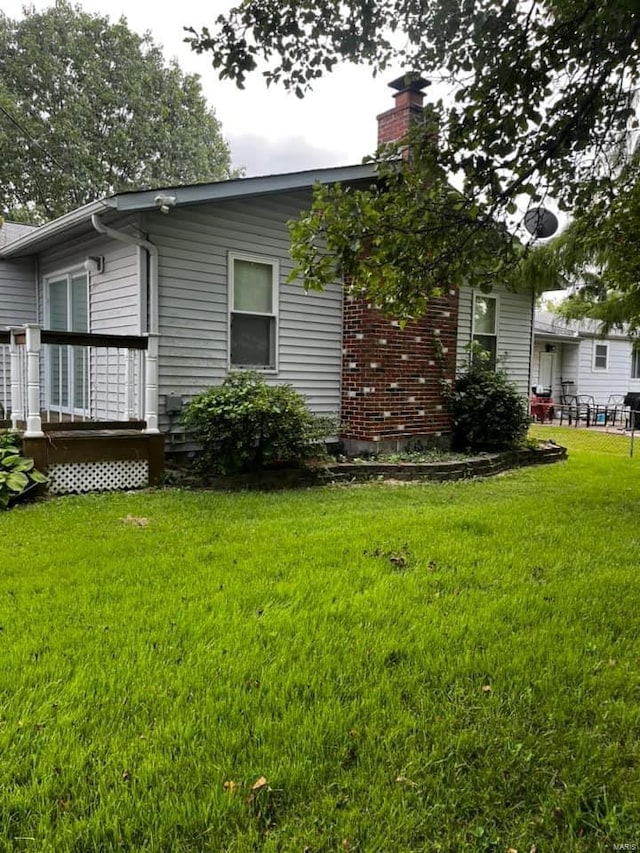 view of home's exterior featuring a yard and a wooden deck