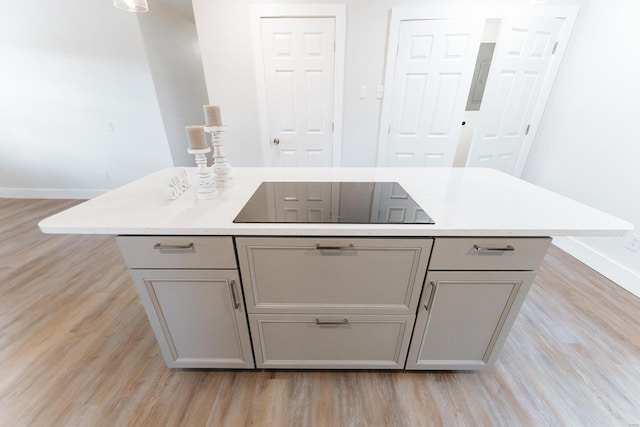 kitchen featuring gray cabinets, light hardwood / wood-style floors, and a center island