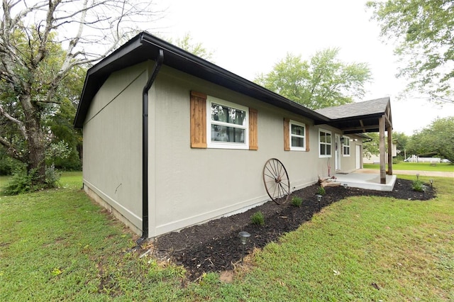 view of property exterior with a yard and a patio area