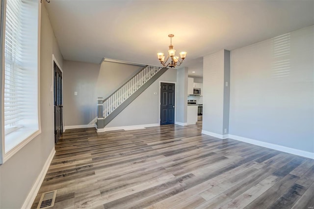 unfurnished living room with hardwood / wood-style floors and a chandelier