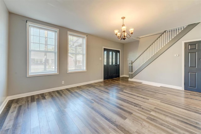 foyer entrance with hardwood / wood-style floors and an inviting chandelier